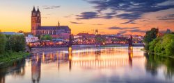 Cityscape image of Magdeburg, Germany with reflection of the city in the Elbe river, during sunset.